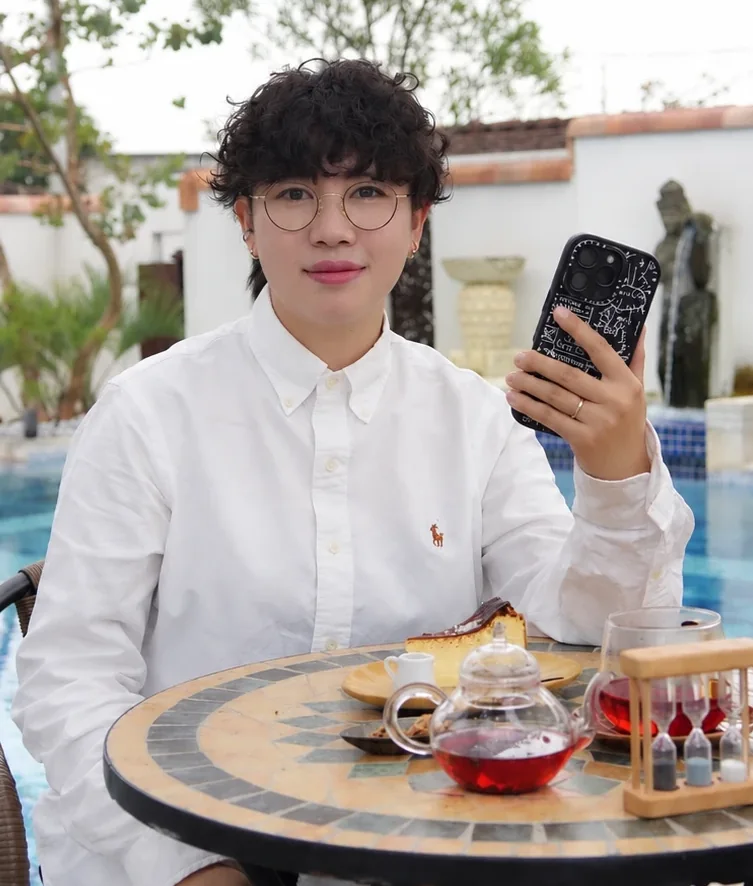 カフェのテーブルでスマホを手にする、いそ